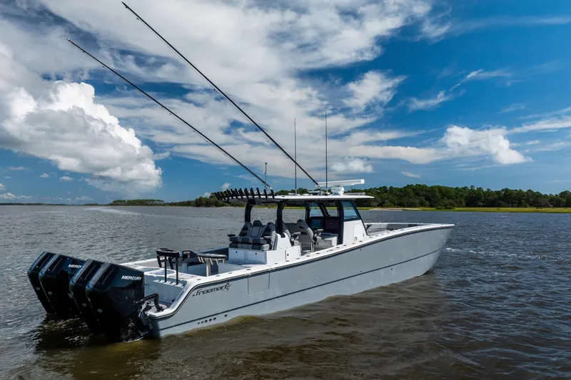  Yacht Photos Pics 2023 Freeman 47 boat on water, featuring dual Mercury engines under a clear blue sky.