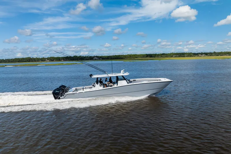  Yacht Photos Pics 2023 Freeman 47 boat cruising on a calm river under a clear blue sky.