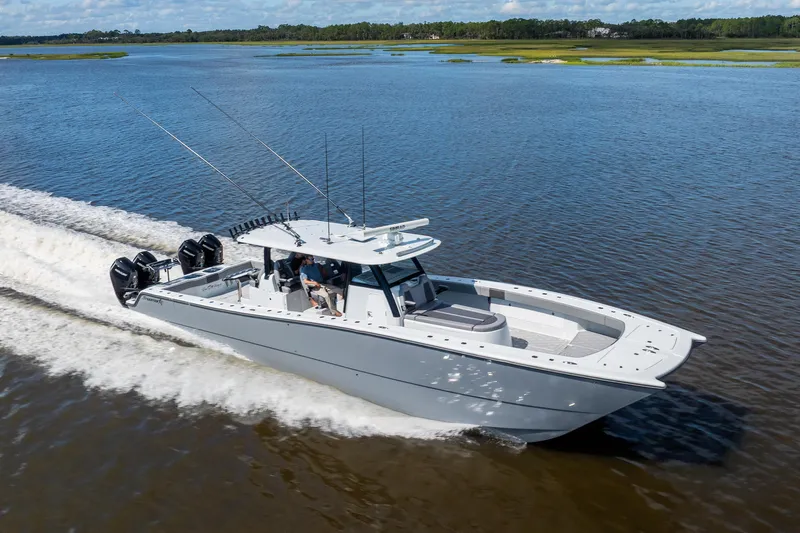  Yacht Photos Pics 2023 Freeman 47 boat cruising on a serene lake with lush green shoreline.