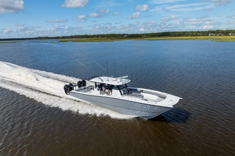  Yacht Photos Pics 2023 Freeman 47 boat cruising on a scenic waterway under a blue sky.