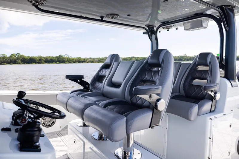  Yacht Photos Pics Luxurious seating on 2023 Freeman 47 boat, featuring sleek design and modern steering controls.