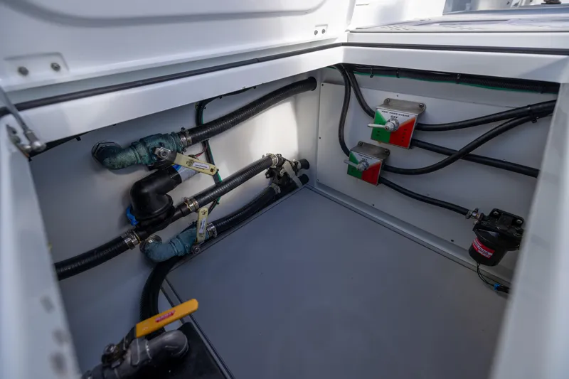  Yacht Photos Pics Freeman 47 boat plumbing system, 2023 model, featuring pipes and valves in a storage compartment.
