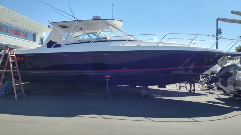  Yacht Photos Pics 2002 Intrepid 377 Walkaround boat on dry dock, side view under clear blue sky.