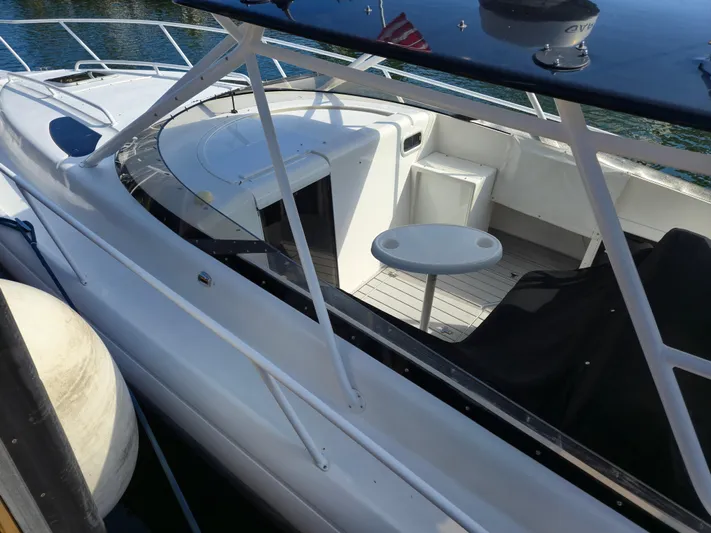  Yacht Photos Pics 2002 Intrepid 377 Walkaround boat with seating and table on deck.