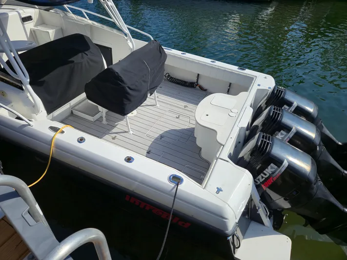  Yacht Photos Pics 2002 Intrepid 377 Walkaround boat with triple Suzuki outboard motors docked in water.