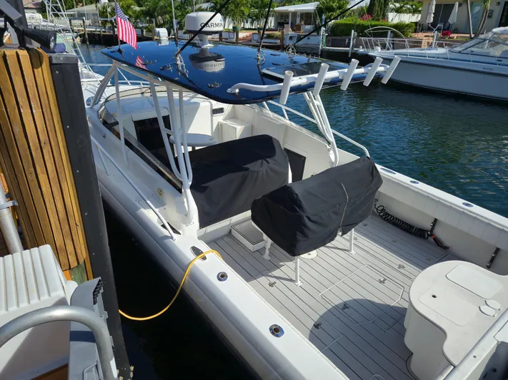 Yacht Photos Pics 2002 Intrepid 377 Walkaround boat docked, featuring covered seating and fishing rod holders.