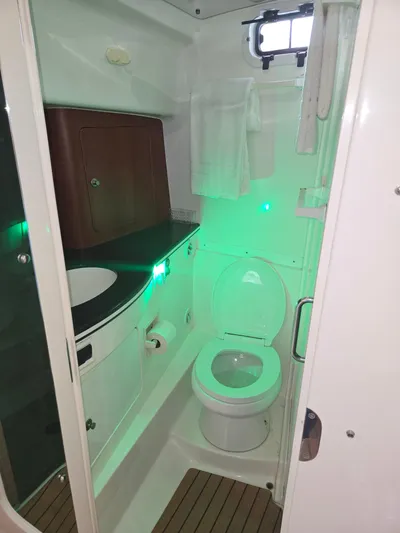  Yacht Photos Pics 2002 Intrepid 377 Walkaround boat bathroom with toilet, sink, and green lighting.
