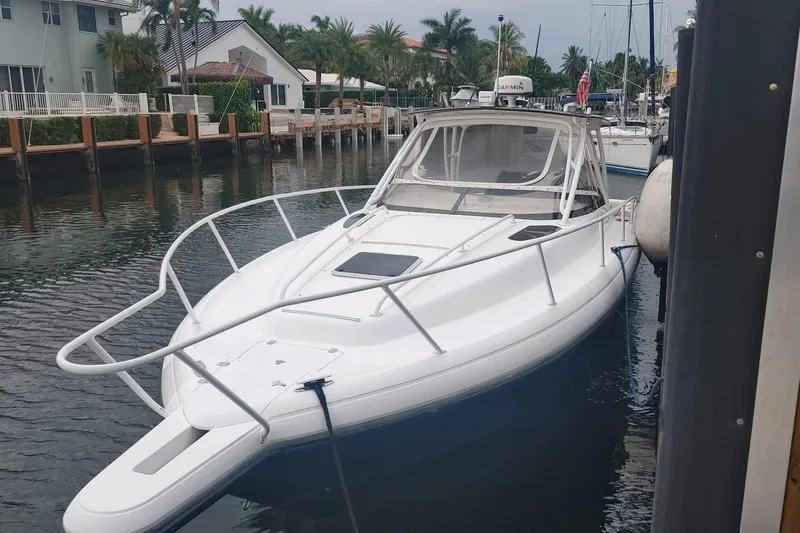  Yacht Photos Pics 2002 Intrepid 377 Walkaround boat docked in a serene waterfront setting.