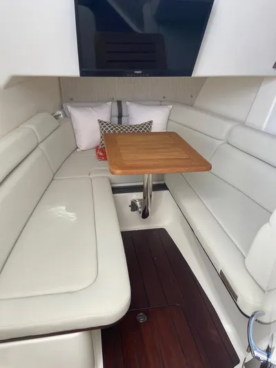  Yacht Photos Pics 2021 Boston Whaler 350 Realm cabin with white seating and wooden table.