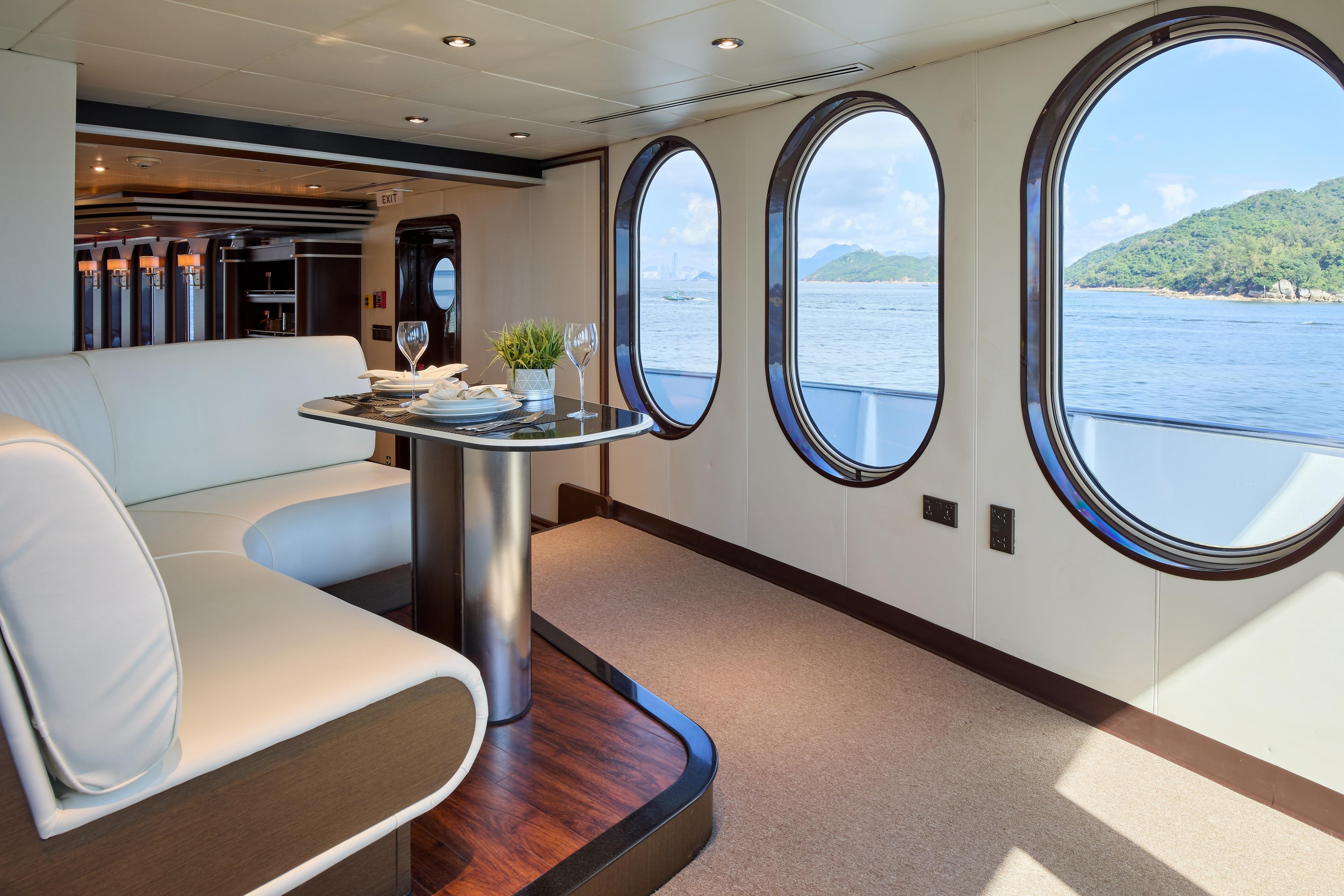 Luxurious interior of 1982 Shadow Marine Custom Expedition Yacht with ocean view through oval windows.