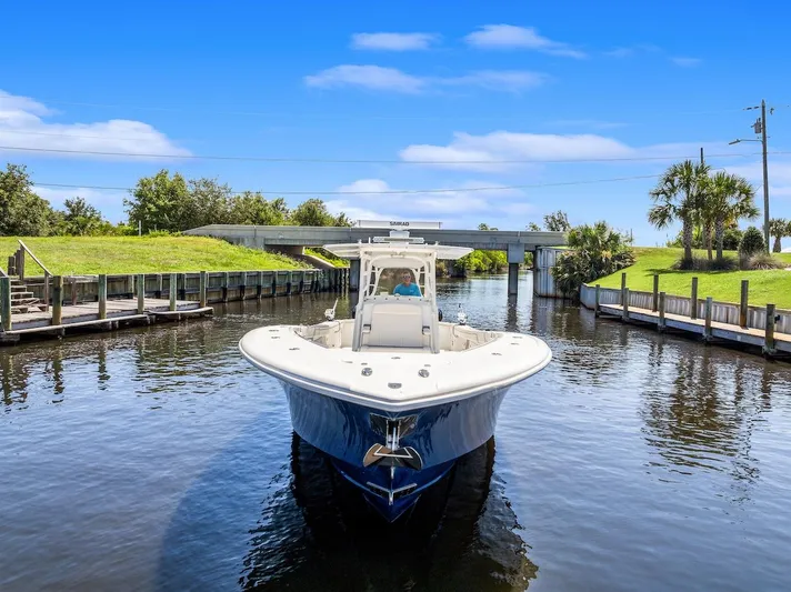  Yacht Photos Pics 2015 Yellowfin 39 boat navigating a calm canal under a clear blue sky.