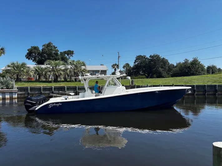  Yacht Photos Pics 2015 Yellowfin 39 boat on calm water, clear sky, and lush greenery in the background.
