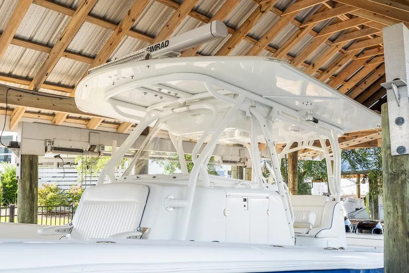  Yacht Photos Pics 2015 Yellowfin 39 boat under wooden shelter, featuring sleek white design and advanced equipment.