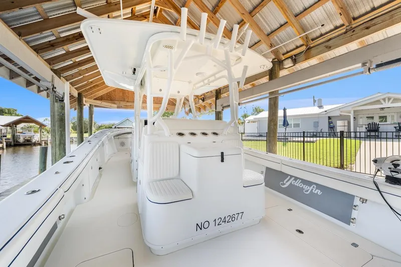  Yacht Photos Pics 2015 Yellowfin 39 boat docked under a wooden canopy, showcasing sleek design and spacious deck.