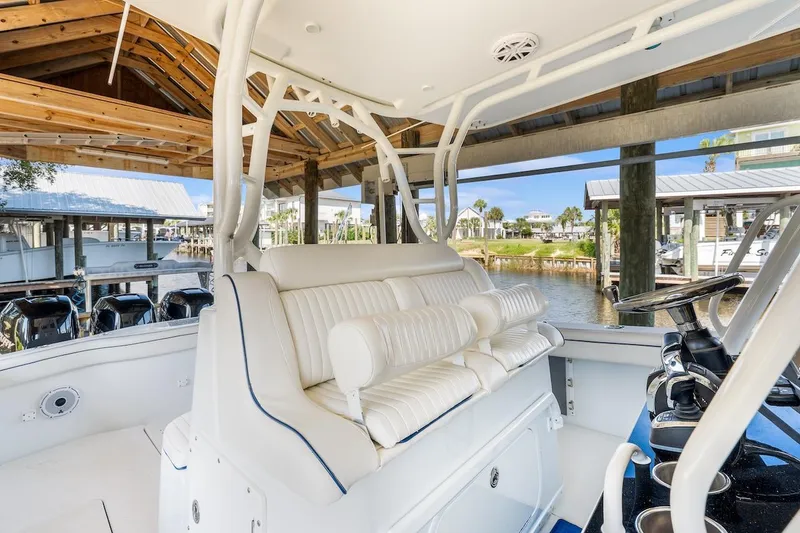  Yacht Photos Pics 2015 Yellowfin 39 boat interior with white seating, docked under a wooden shelter.