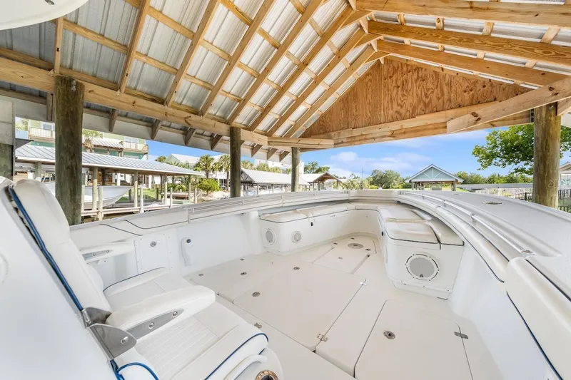  Yacht Photos Pics 2015 Yellowfin 39 boat under wooden shelter, showcasing spacious seating and sleek design.
