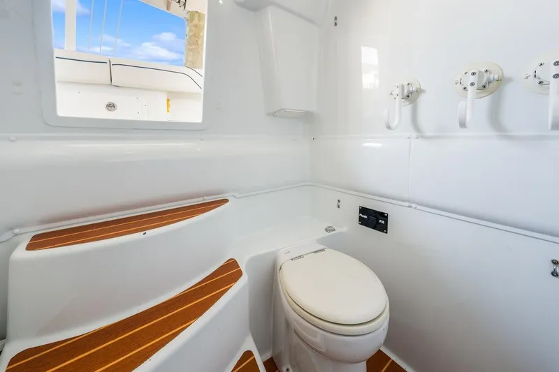  Yacht Photos Pics Interior of 2015 Yellowfin 39 boat featuring a compact marine toilet and wooden steps.