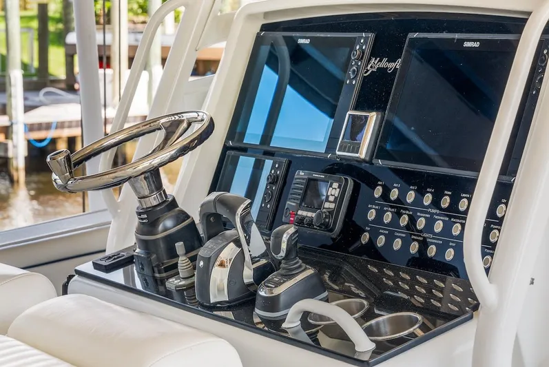  Yacht Photos Pics Control panel of a 2015 Yellowfin 39 boat with steering wheel and navigation screens.