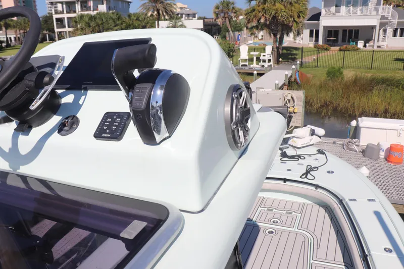 Island Time Yacht Photos Pics Control panel of a 2020 BARKER 26 boat with modern steering and throttle.