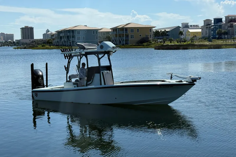 Island Time Yacht Photos Pics 2020 Barker Boatworks 26 on calm water, with waterfront buildings in the background.