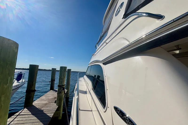  Yacht Photos Pics 2003 Sea Ray 480 Sedan Bridge yacht docked under clear blue sky.