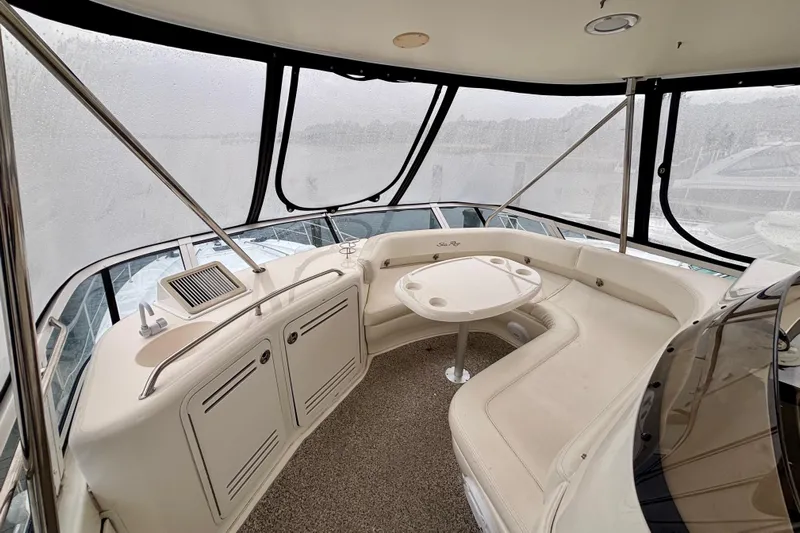  Yacht Photos Pics 2003 Sea Ray 480 Sedan Bridge interior with seating and table, enclosed by clear panels.