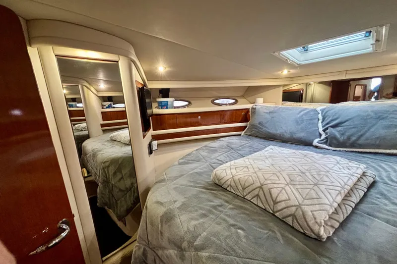  Yacht Photos Pics Luxurious 2003 Sea Ray 480 Sedan Bridge bedroom with cozy bedding and elegant wood finishes.