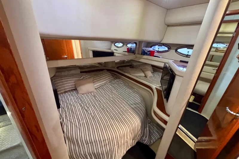  Yacht Photos Pics 2003 Sea Ray 480 Sedan Bridge cabin interior with striped bedding and porthole windows.