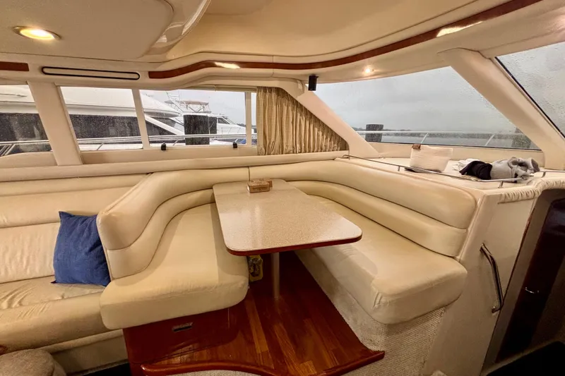  Yacht Photos Pics Luxurious interior of 2003 Sea Ray 480 Sedan Bridge yacht with plush seating and table.