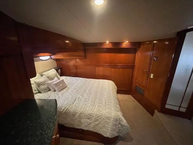 Ocean Life Yacht Photos Pics Luxurious bedroom interior of 2000 Carver 530 Voyager Pilothouse yacht with wood paneling.