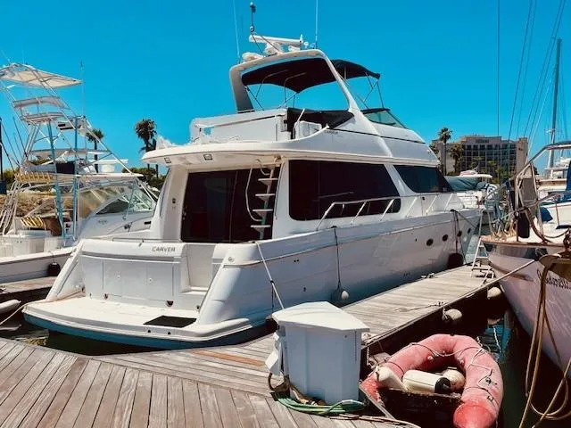 Ocean Life Yacht Photos Pics 2000 Carver 530 Voyager Pilothouse yacht docked at marina under clear blue sky.