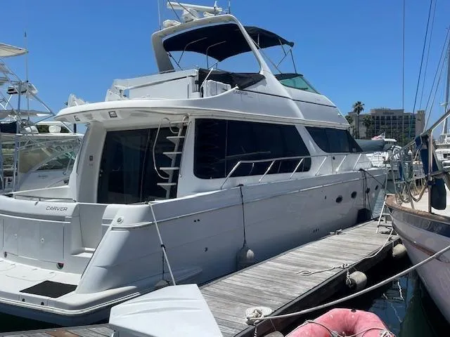 Ocean Life Yacht Photos Pics 2000 Carver 530 Voyager Pilothouse yacht docked at marina under clear blue sky.