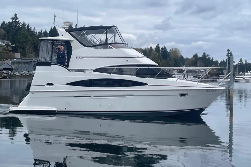  Yacht Photos Pics 2002 Carver 346 Aft Cabin yacht on calm water, with scenic forested background.