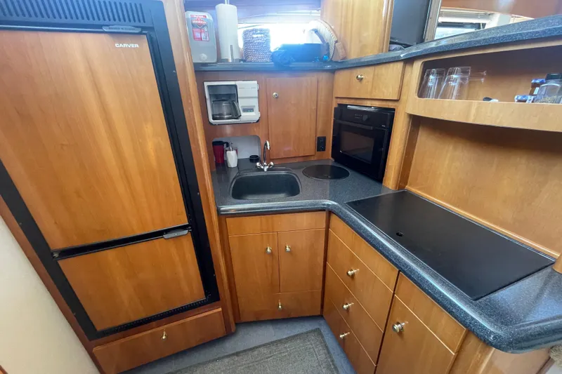  Yacht Photos Pics 2002 Carver 346 Aft Cabin kitchen with wood cabinetry, sink, and appliances.