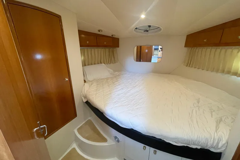  Yacht Photos Pics Cozy bedroom in 2002 Carver 346 Aft Cabin yacht with wood accents and circular steps.