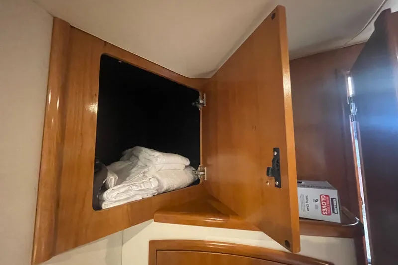  Yacht Photos Pics Open wooden cabinet in 2002 Carver 346 Aft Cabin with towels and gloves box.