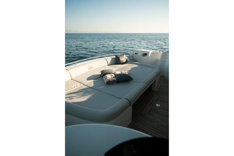  Yacht Photos Pics Luxurious 2006 Pershing 62' yacht deck with cushions, overlooking serene ocean waters.
