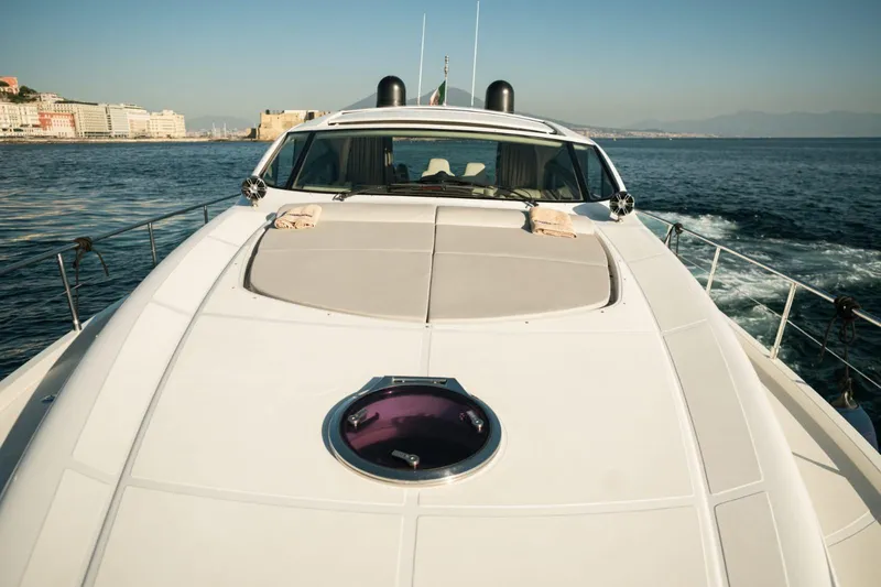  Yacht Photos Pics Luxury 2006 Pershing 62' yacht cruising on open water, cityscape in background.