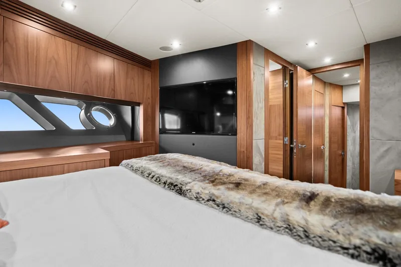  Yacht Photos Pics Luxurious bedroom interior of 2014 Sunseeker 75 Yacht with modern wood finishes and large TV.