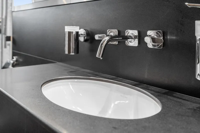  Yacht Photos Pics Modern bathroom sink on 2014 Sunseeker 75 Yacht with sleek black countertop and chrome fixtures.