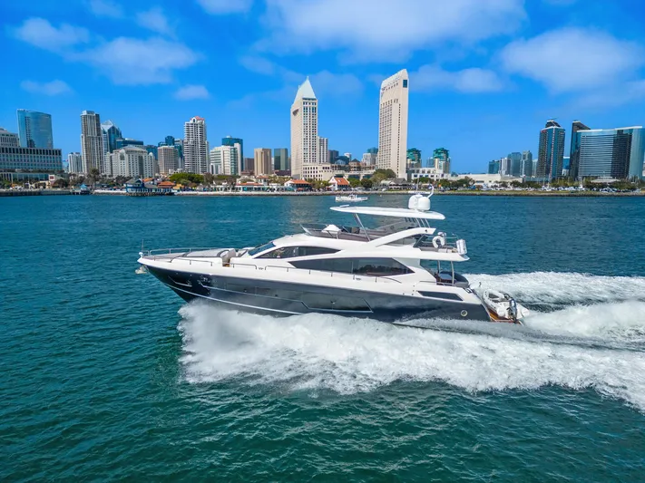  Yacht Photos Pics Sunseeker 75 Yacht 2014 cruising in a city harbor with skyscrapers in the background.