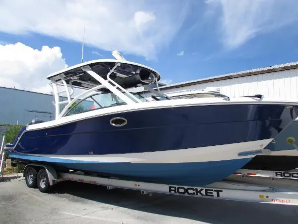 317-147 Ray Brokerage Yacht Photos Pics 2018 Robalo R317 Dual Console boat on trailer, blue and white design.