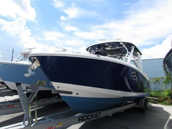 317-147 Ray Brokerage Yacht Photos Pics 2018 Robalo R317 Dual Console boat on trailer under blue sky.