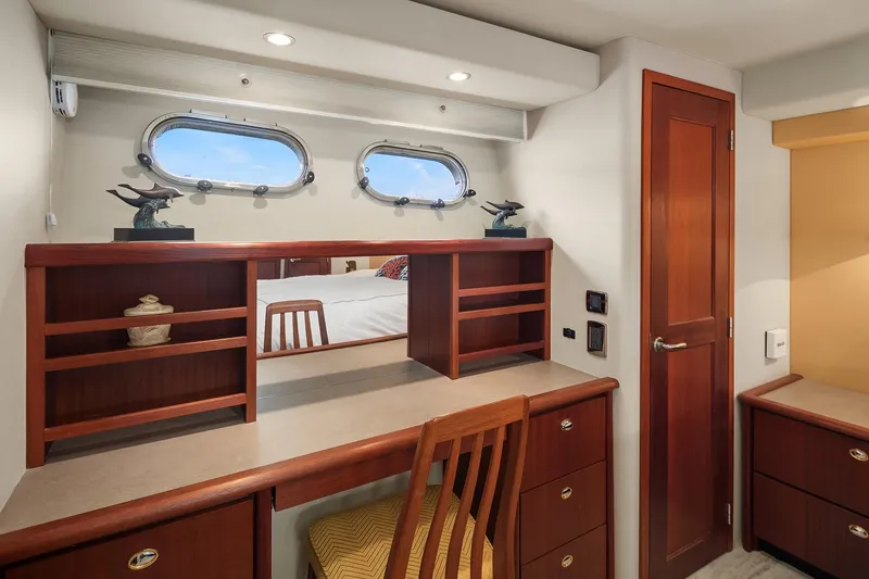Escencia Yacht Photos Pics 2003 Pacific Mariner Pilothouse interior with wooden desk, chair, and porthole windows.