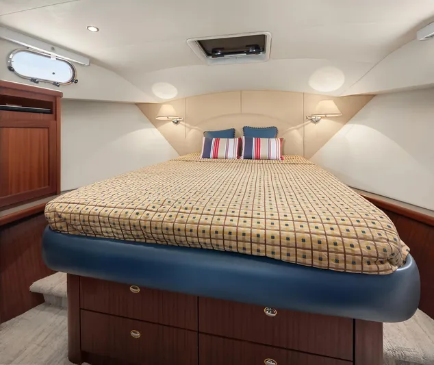 Escencia Yacht Photos Pics Luxurious 2003 Pacific Mariner Pilothouse bedroom with elegant bedding and wooden cabinetry.