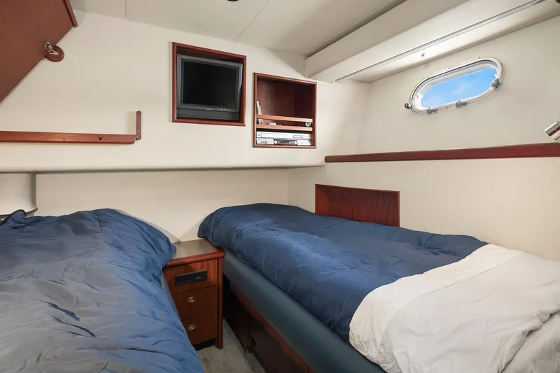 Escencia Yacht Photos Pics 2003 Pacific Mariner Pilothouse cabin with twin beds, porthole, and TV.