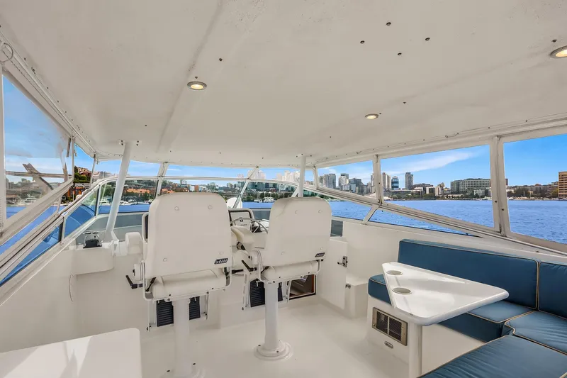 Escencia Yacht Photos Pics 2003 Pacific Mariner Pilothouse interior with seating, helm, and city skyline view.