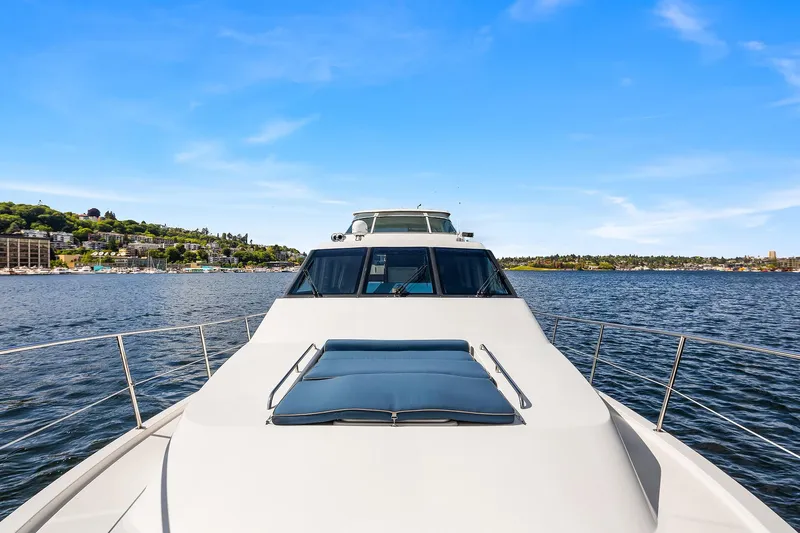 Escencia Yacht Photos Pics 2003 Pacific Mariner Pilothouse yacht cruising on a serene lake under a clear blue sky.