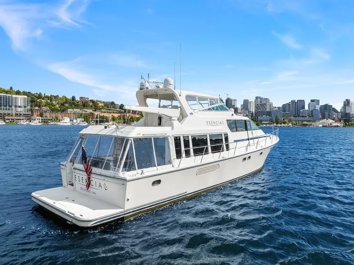 Escencia Yacht Photos Pics 2003 Pacific Mariner Pilothouse yacht cruising on a sunny day with city skyline in background.