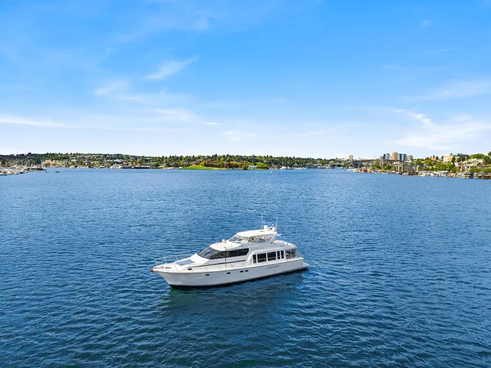 Escencia Yacht Photos Pics 2003 Pacific Mariner Pilothouse yacht cruising on a serene blue lake under a clear sky.